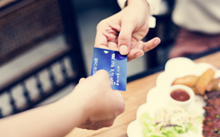 Woman paying lunch with credit card at restaurant